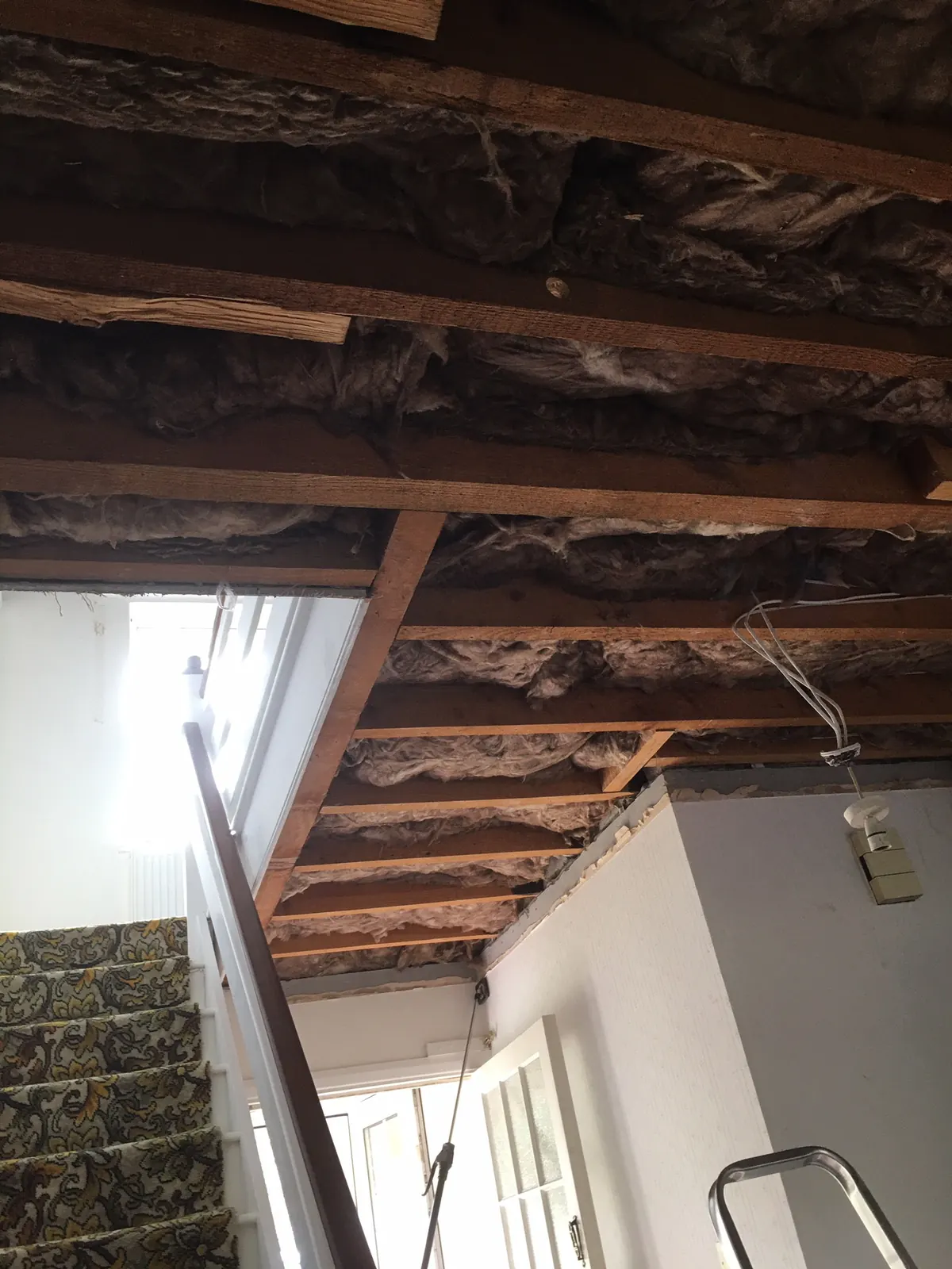 Inside a loft looking up at the rafters, with foil-faced breather membrane draped between them