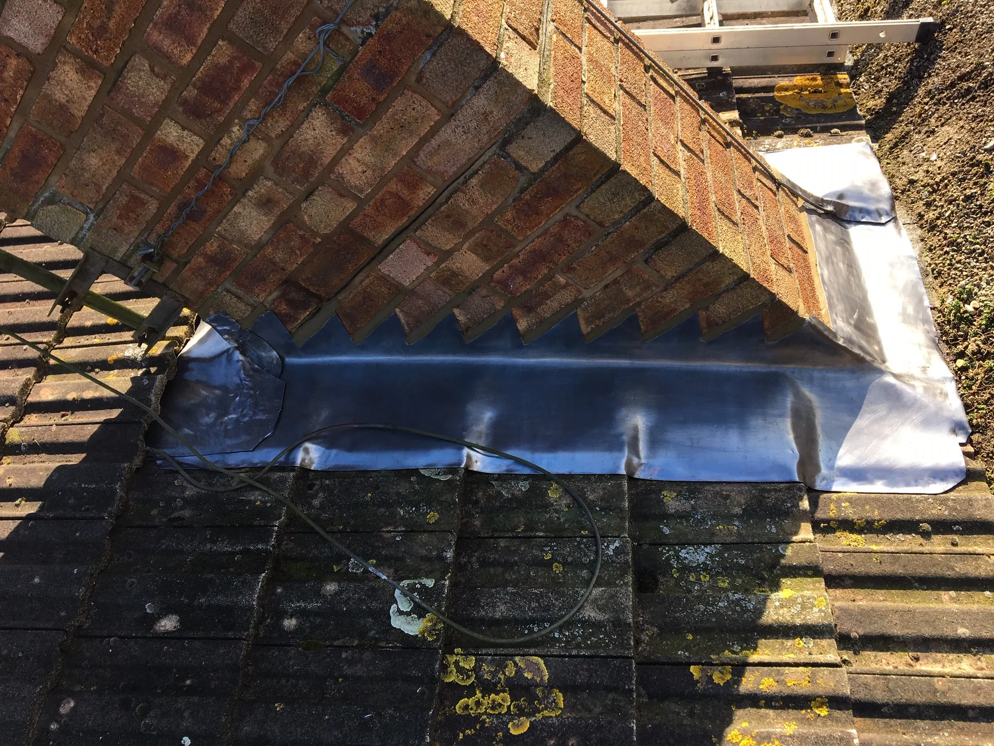 Leadwork dressed into brickwork alongside tiles
