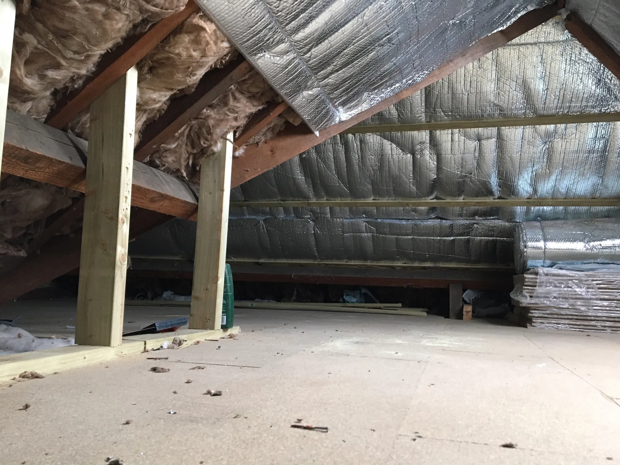 A loft interior with exposed rafters and foil-faced membrane