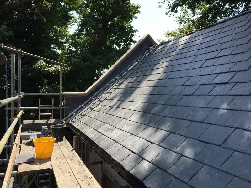 Slates part way through being laid, courses climbing the roof