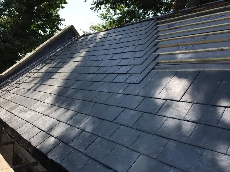 Slates mid-lay with the battens still showing above the finished courses