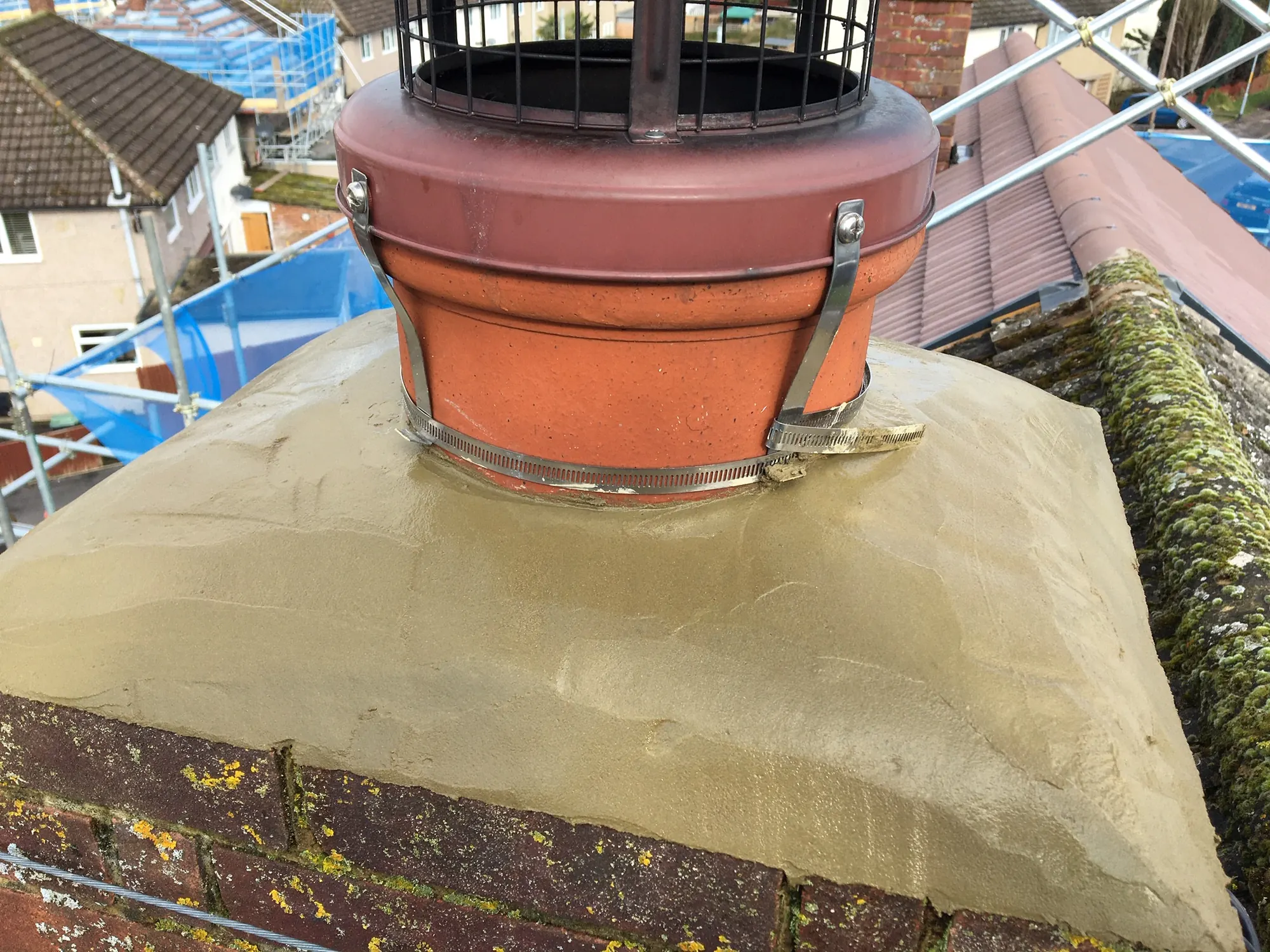 The same rebuilt chimney stack from a second angle, new pot strapped, fresh flaunching